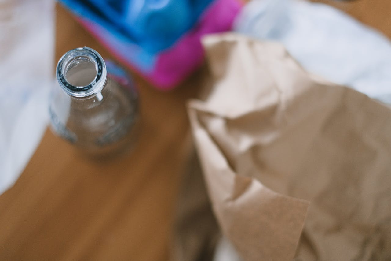 services-02 Top view of empty glass bottle with creased paper and egg container prepared for recycling